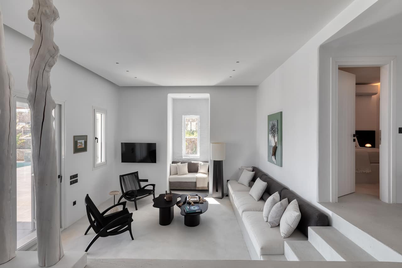 The open living room — a long built-in sofa, a driftwood column