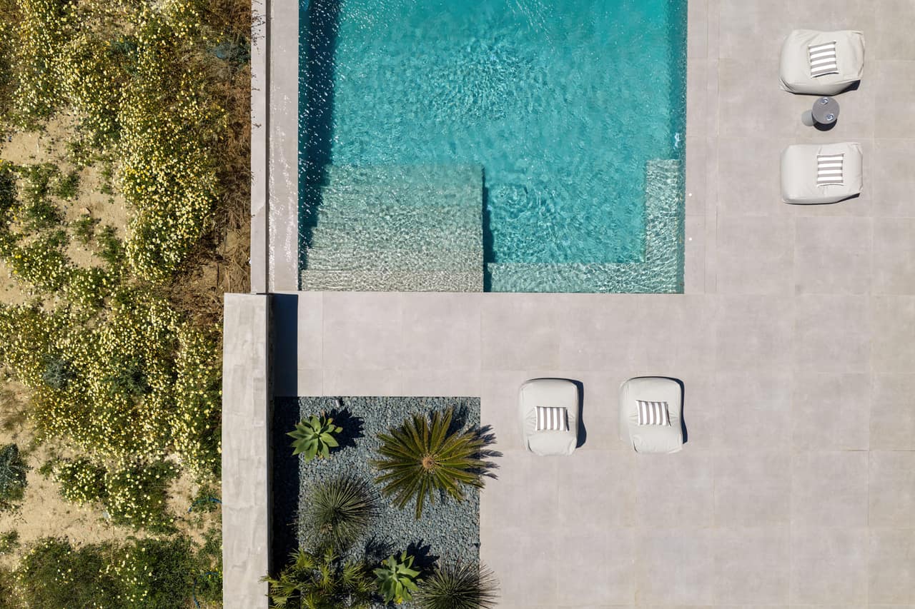 The pool from above — a clean rectangle of turquoise set into the stone