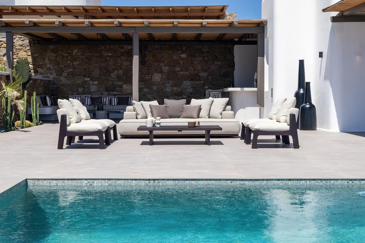 The outdoor stone bar by day, striped stools under a bamboo pergola