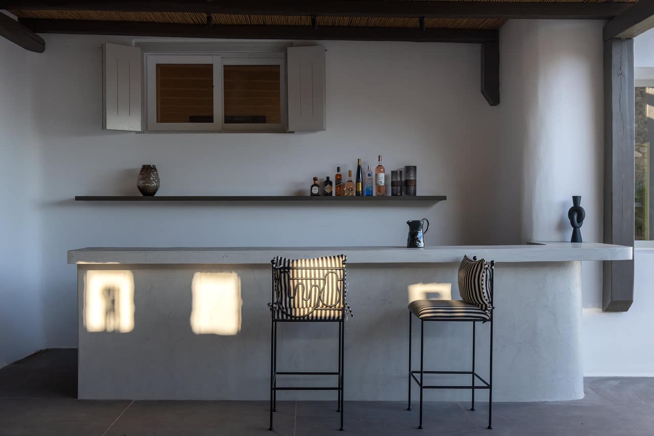 The stone bar at dusk, light pooling across the floor