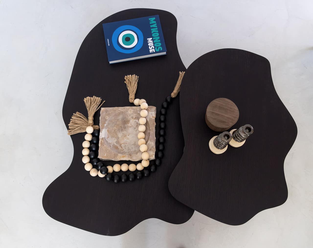 Two dark organic tables, beads and stone — a corner of the living room