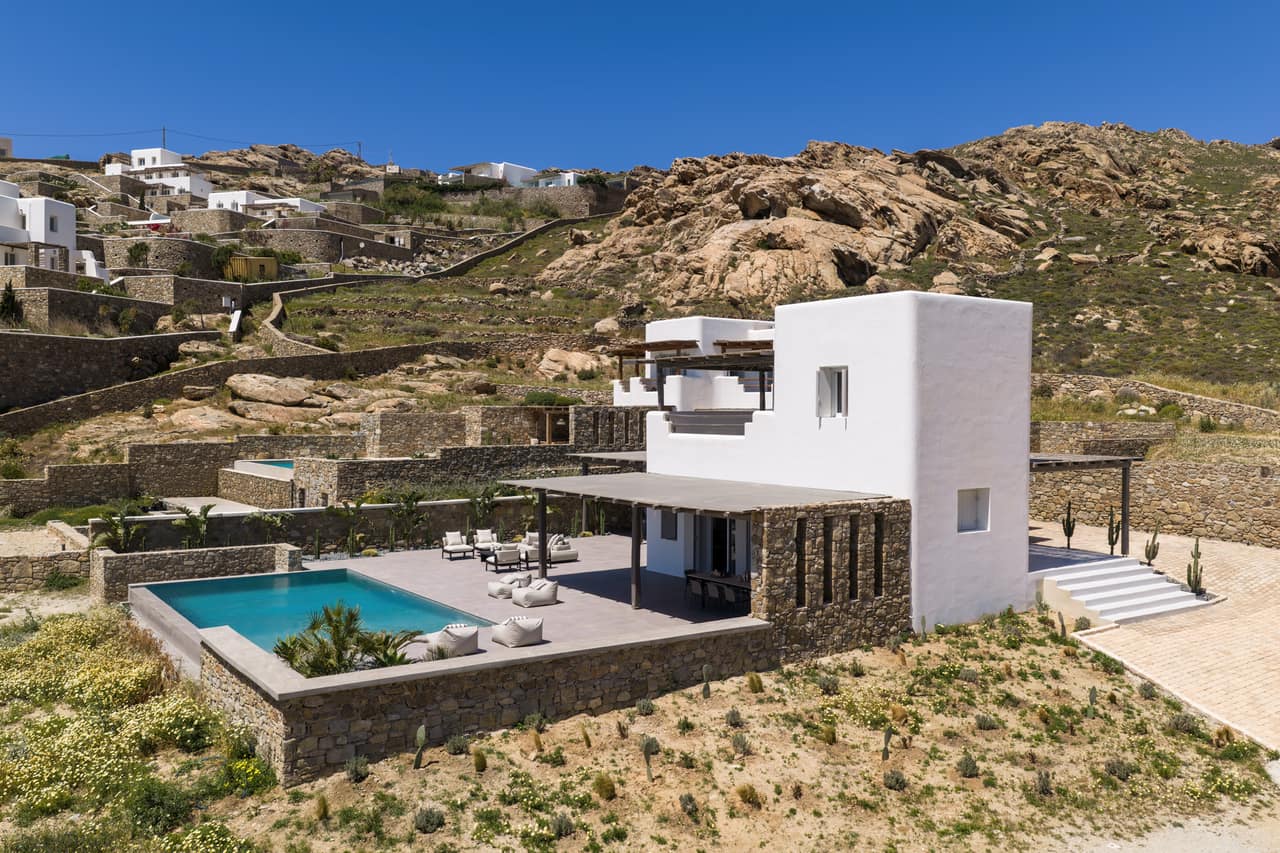 The villa's white volumes set against the bare hillside